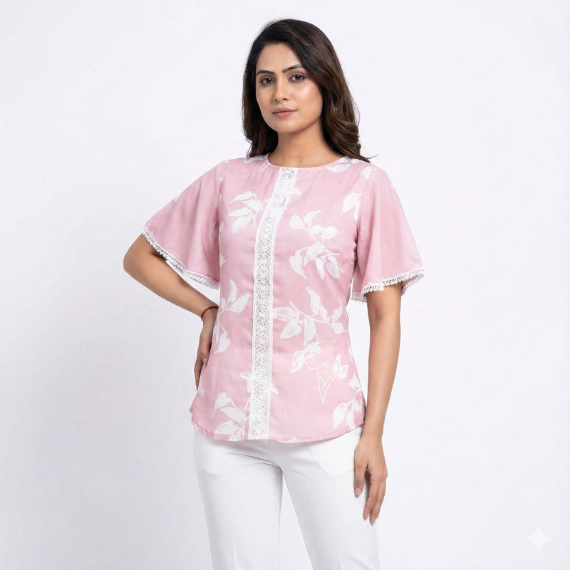 Woman wearing a pink blouse with white floral patterns on a white background